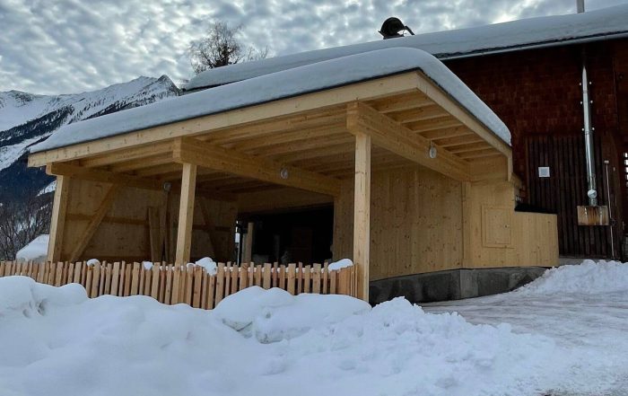 Moderner Carport aus Holz mit Satteldach im Winter, gebaut von BRUNNER & Co in Neukirchen